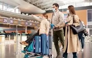 mother father and daughter with a trolly walking through an airport